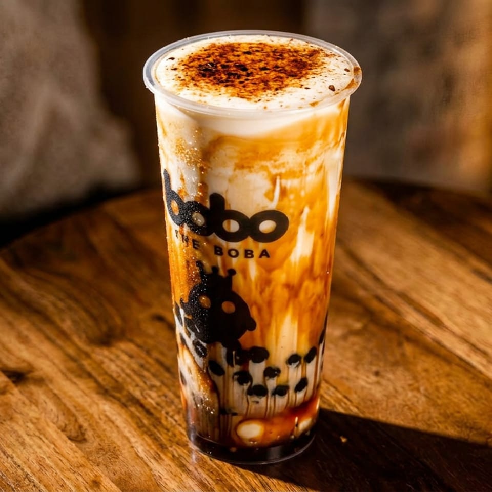Boba The Boba's creme brulee brown sugar boba tea with tapioca pearls on a wooden table.